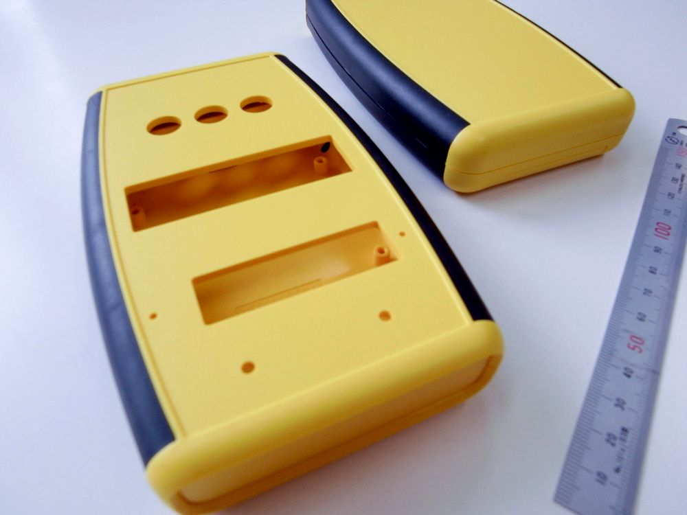 ABS難燃グレード製プラスチックケースに追加工した貫通四角穴と貫通丸穴周辺を拡大したクローズアップ写真（3軸マシニングセンターによる精密切削加工とバリ取り仕上げの状態）