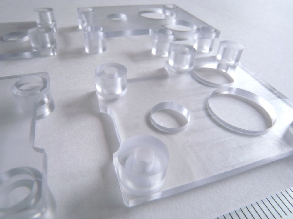 透明PVCマシニング加工品の裏面写真（3つの貫通穴とザグリ・島残し加工の詳細）