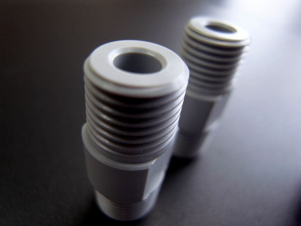 PVC樹脂切削加工品 R1/4テーパーオスネジ部と中央部10mmに施した幅12mm・2面平削り部の拡大写真